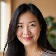 Portrait of Sophia Chen, a vibrant and insightful woman with long dark hair, smiling gently. She carries an aura of calm and wisdom.