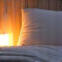 A tranquil bedroom scene with soft lighting and comfortable bedding, symbolizing restful sleep.