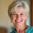 Portrait of Sarah H., a smiling woman in her early 50s, looking vibrant and confident.